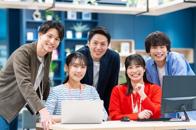 ノートパソコンを開きながら笑顔の男女